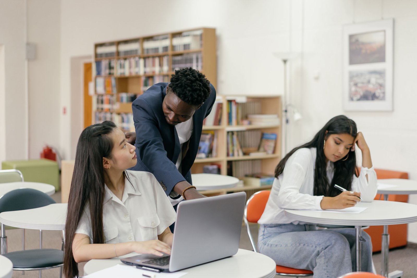 Teacher guiding students with technology